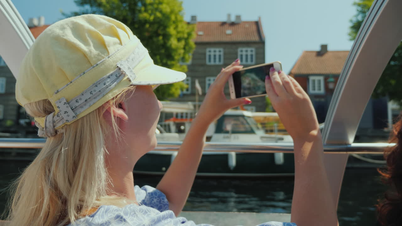 한 여성이 코펜하겐의 도시 라인을 배경으로 자신의 사진을 찍습니다.