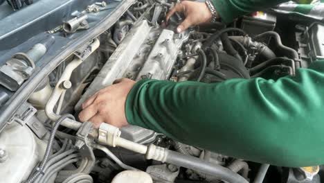 mechanic expertly assembles cylinder headcover of a car engine