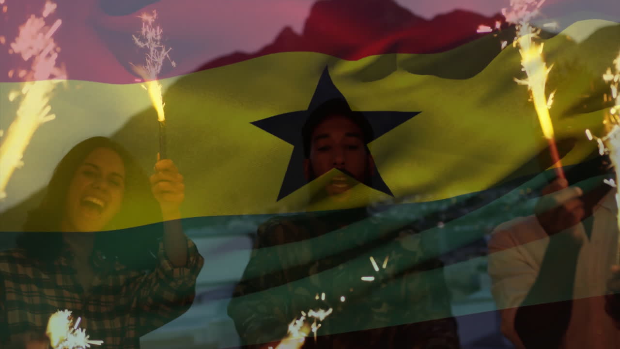 Celebrating with sparklers, people in front of animation of Ghana flag and cityscape