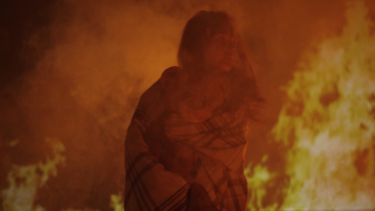 Shadowy Figure Holding a Teddy Bear in Flames