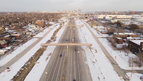 aerial forwarding shot of a busy highway going through a urban city during a nice winter day