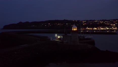 Vista-Del-Puerto-De-Howth-Por-La-Noche-Con-Las-Luces-De-La-Ciudad-Y-Los-Faros-En-Primer-Plano