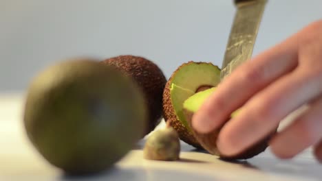Removing-centre-seed-of-sliced-avocado-with-a-knife
