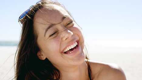 Close-up-portrait-of-beautiful-young-woman-smiling-on-tropical-beach-slow-motion