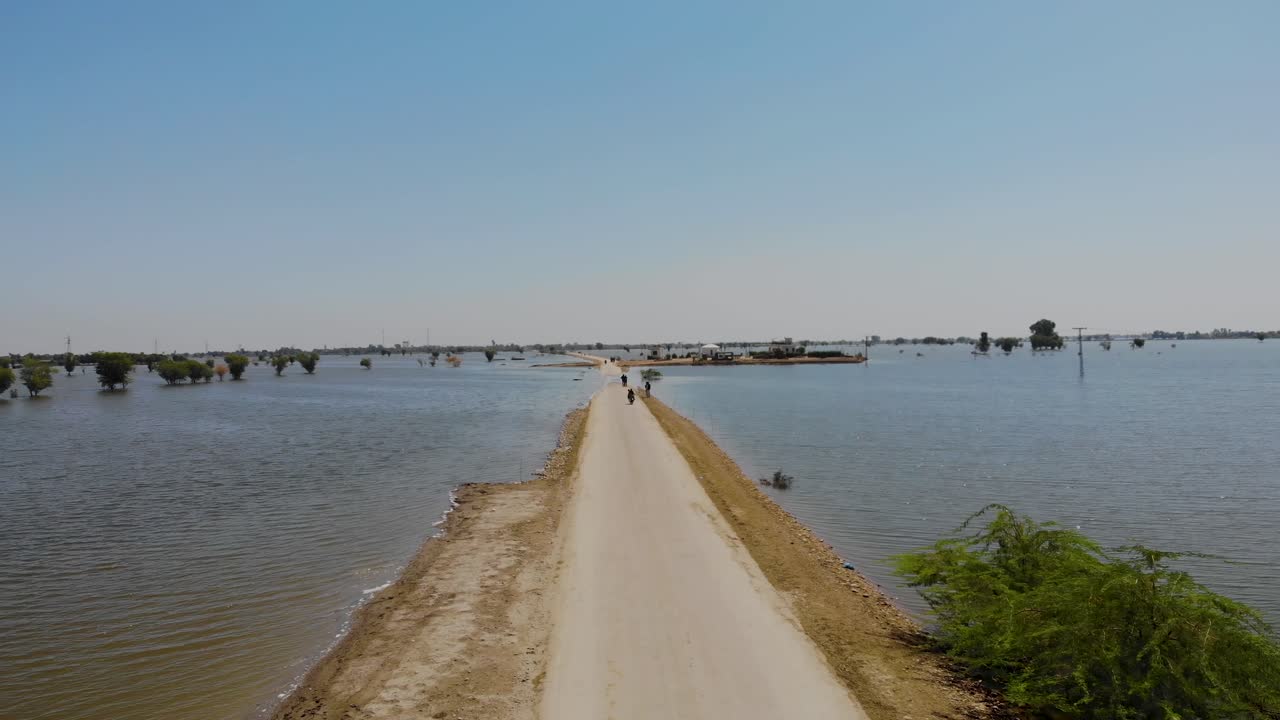 Volo aereo lungo l'unica strada attraverso il paesaggio allagato a Maher, Sindh