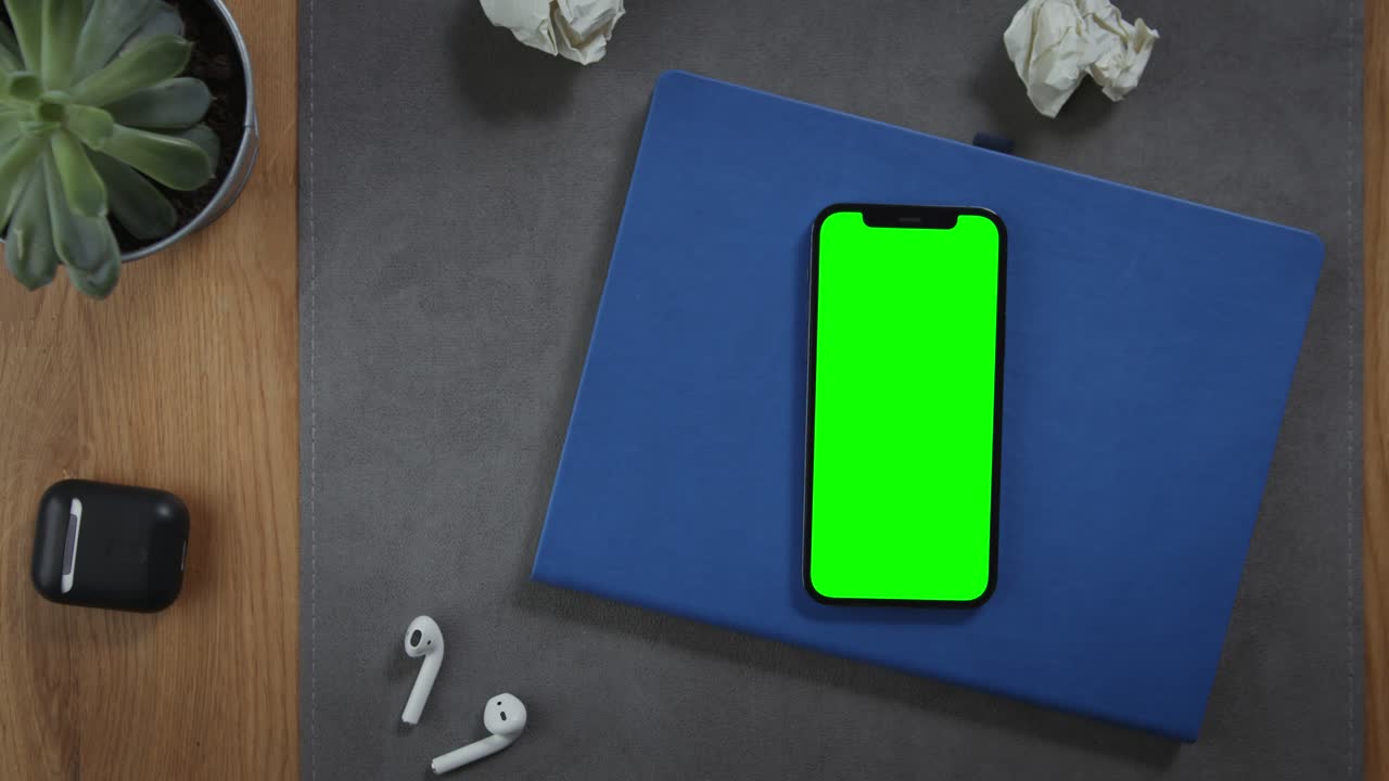 teléfono inteligente con pantalla verde en un escritorio