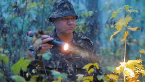 a man shines a flashlight at dusk in the forest search operation