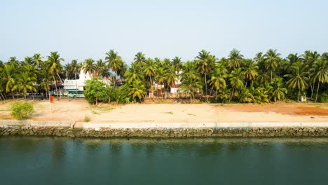 aerial drone shot of an island landscape with coconut tree-lined villages in udupi