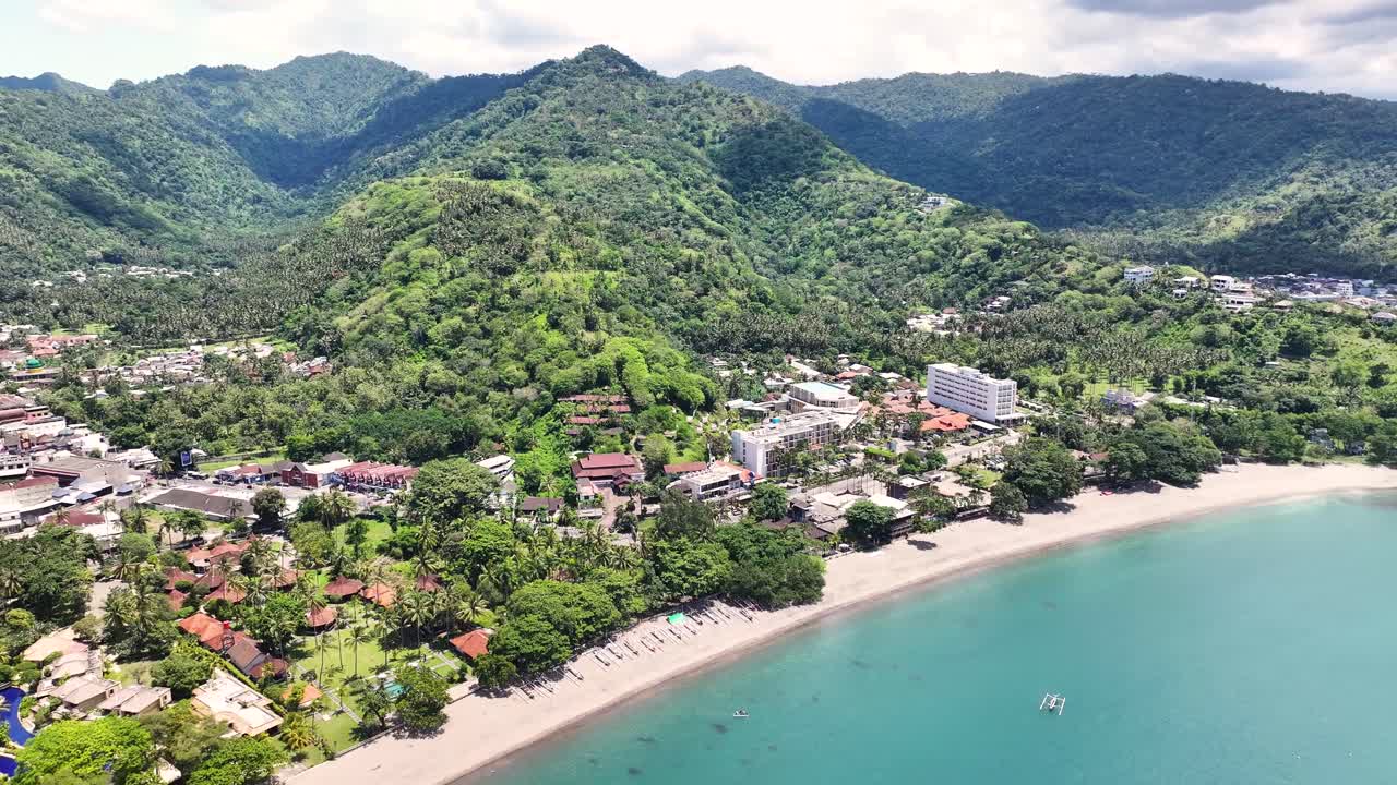 vista aérea de una ciudad de playa tropical con montañas en el fondo