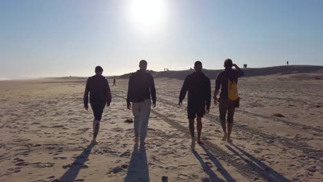 friends walking on a beach at sunset