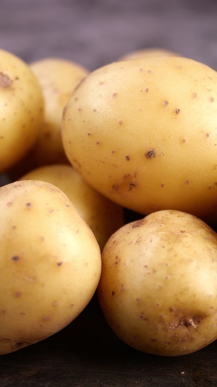 Close-up of Fresh Raw Potatoes on a Dark Wooden Surface