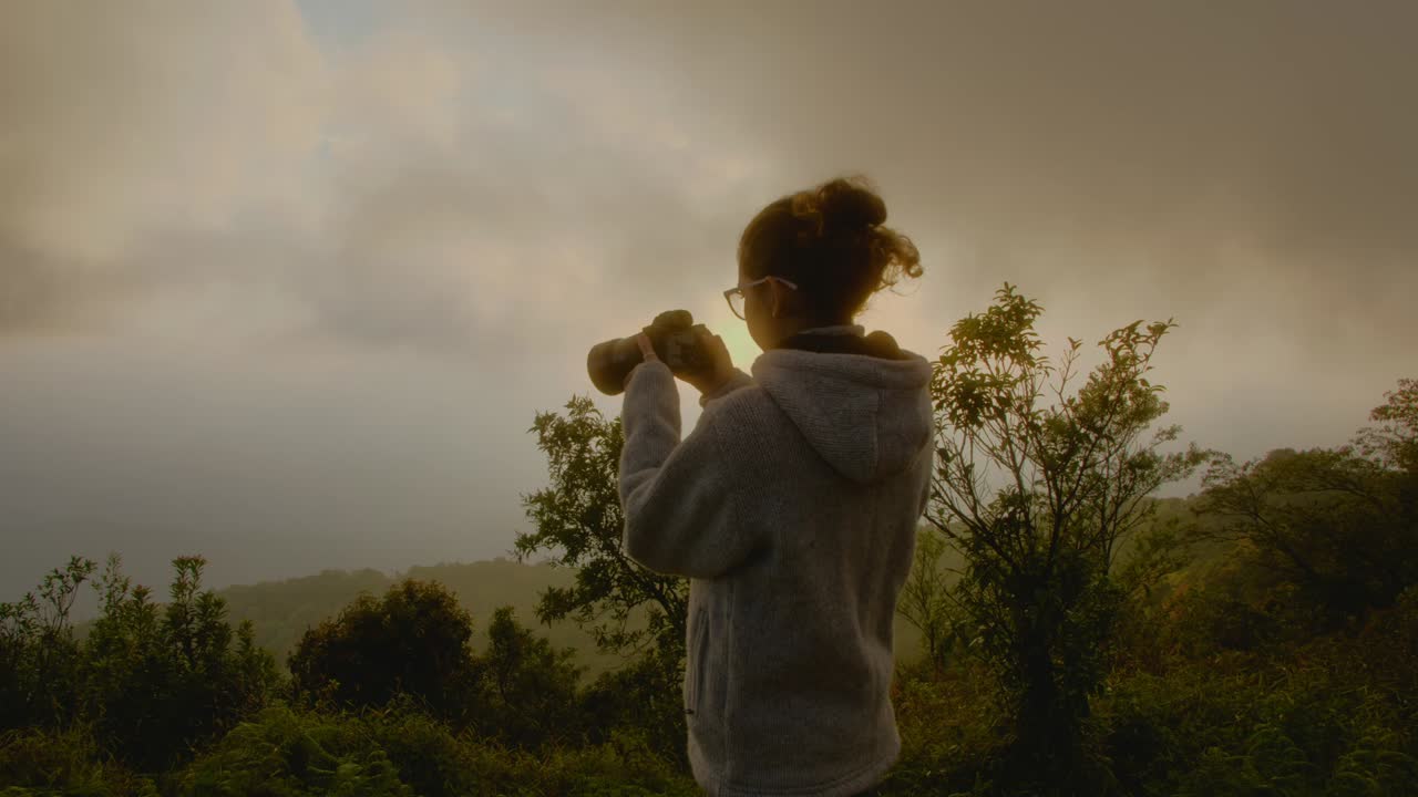 Woman taking a Sunrise Photo in Mountains