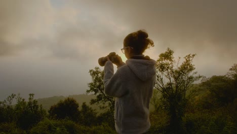 woman taking a sunrise photo in mountains
