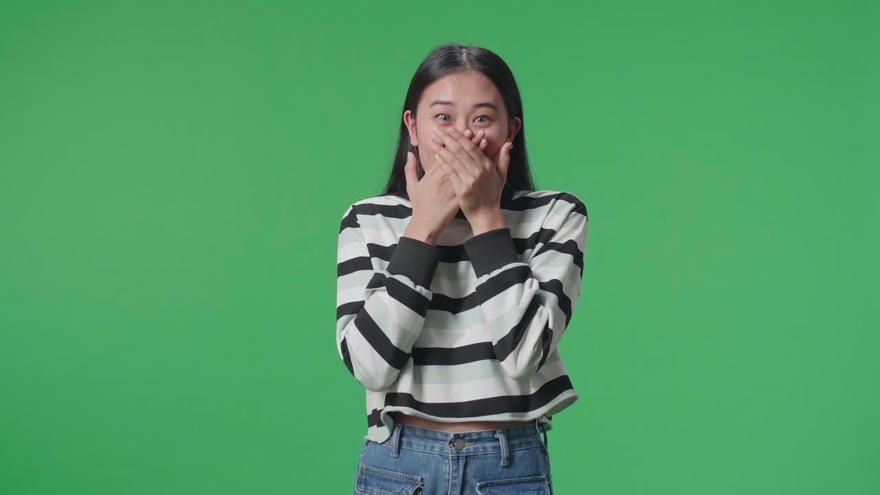 Asian Woman Surprised While Standing In Front Of Green Screen Background