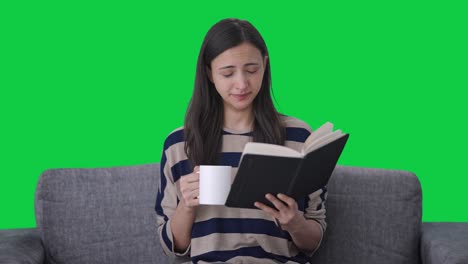 Tired-Indian-girl-reading-book-and-drinking-coffee-Green-screen