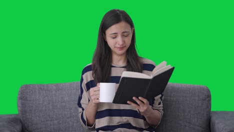 chica india cansada leyendo un libro y bebiendo café pantalla verde