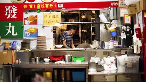 vendor prepares food at bustling street stall