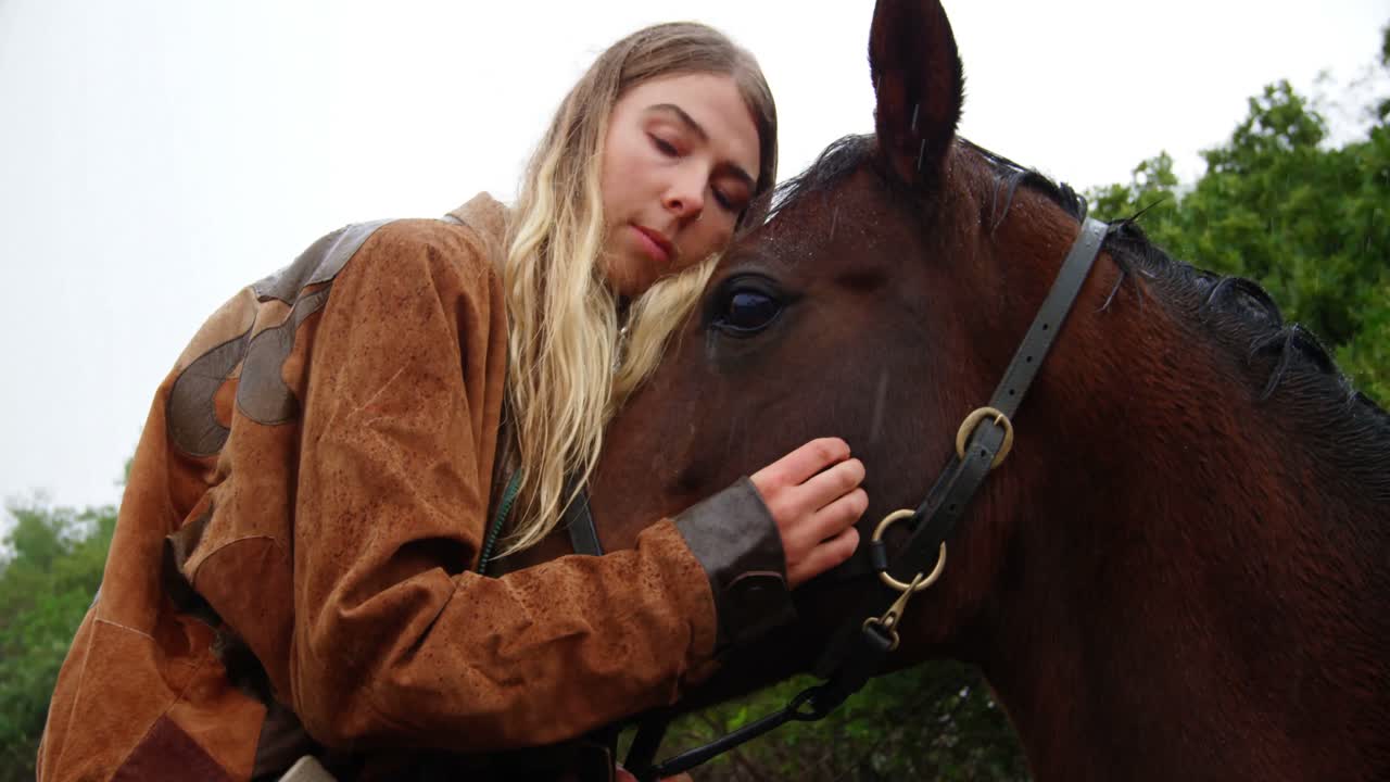 Woman kissing horse on wooden fence at ranch 4k