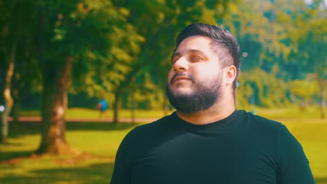 orbital shot of a young man breathing outdoors at a parkl