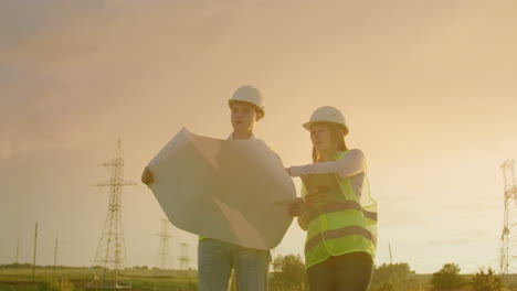 Ingeniero-Y-Supervisor-Con-Tableta-Y-Los-Dibujos-Tratan-Sobre-Líneas-Y-Torres-De-Transmisión-Y-Discuten-El-Plan-De-Expansión-Y-La-Energía-De-Transporte-Para-Pueblos-Y-Ciudades.