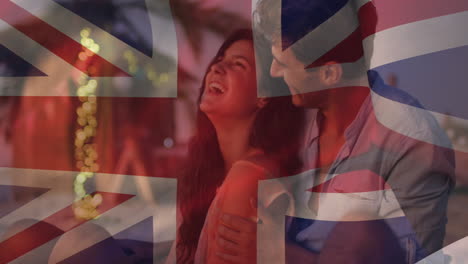 animación de la bandera del reino unido ondeando sobre una feliz pareja caucásica pasando su tiempo libre