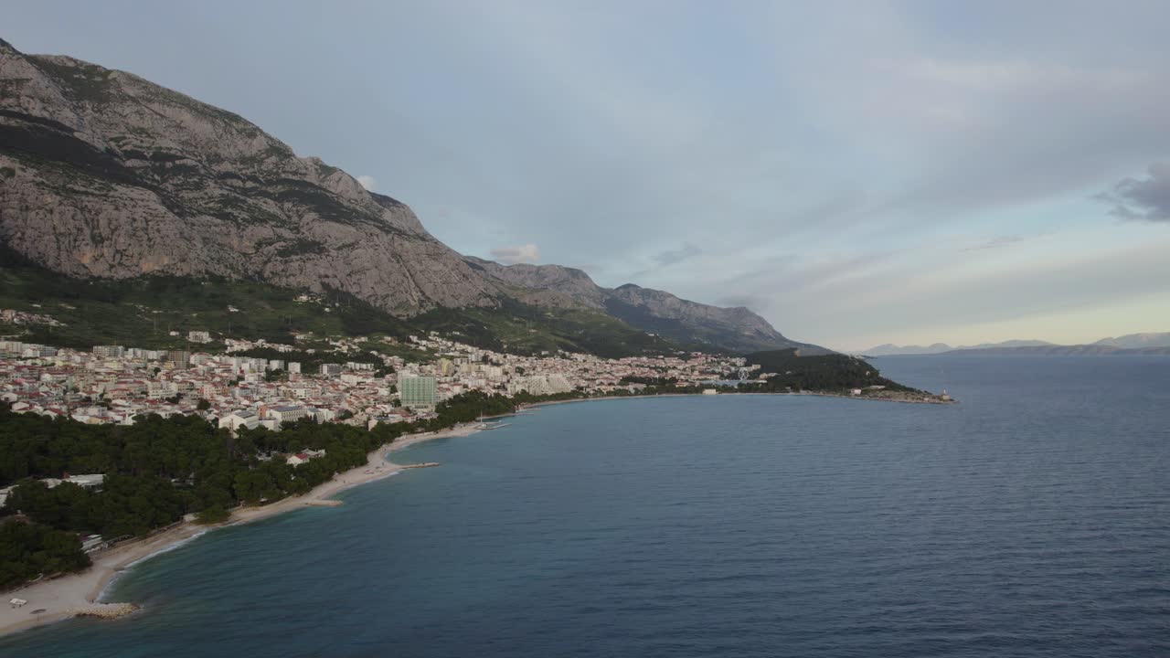 Makarska, Croazia, con montagne e costa che incontrano il mare Adriatico al tramonto, veduta aerea.