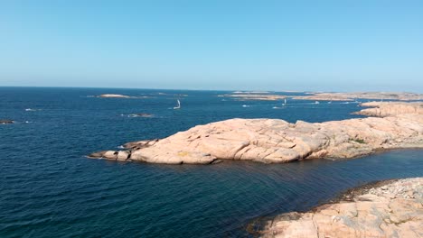 drone aerial view, sailboats by valon nature reserve coastline, sweden on windy sunny summer day