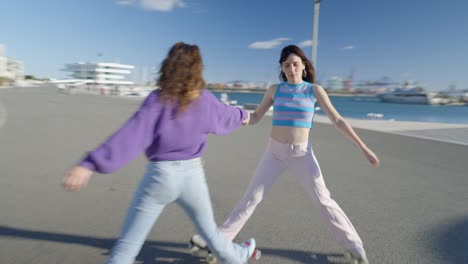 two girls roller skating together at the harbor