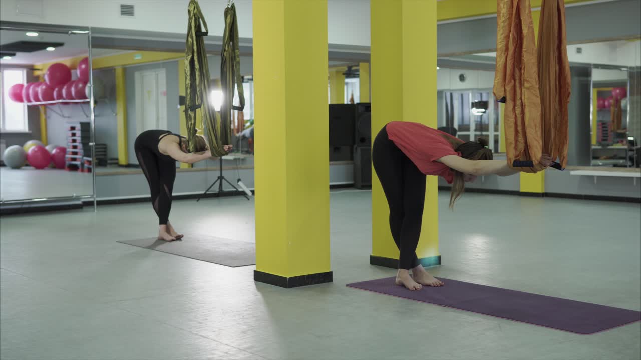 Women Practicing Aerial Yoga in a Gym