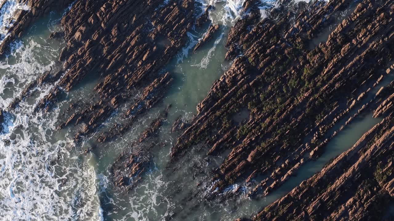 Rocky coastline in ballycotton, county cork, ireland, with ocean waves, aerial view