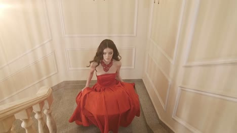 woman in red gown on grand staircase
