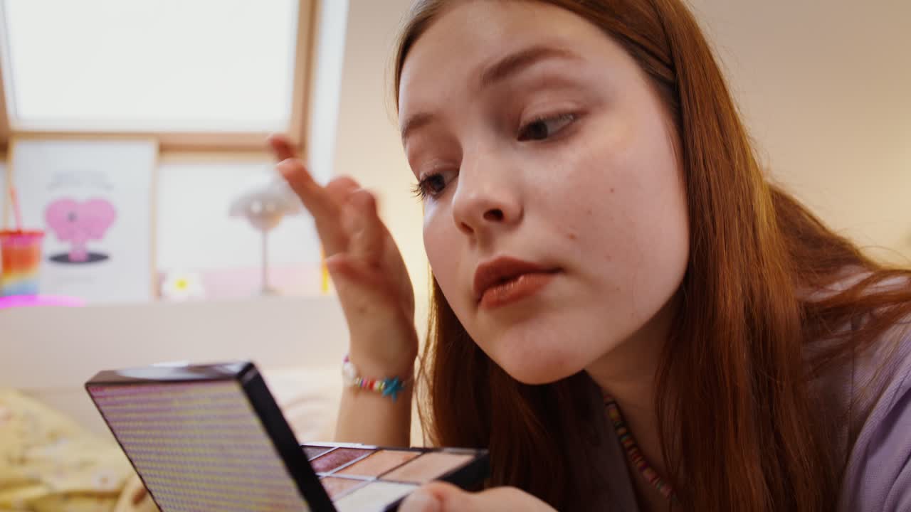 una adolescente aplicando maquillaje