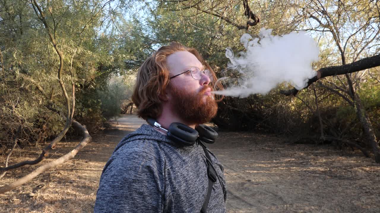 красноволосый мужчина вдыхает облака вблизи.