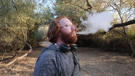 el hombre de pelo rojo vapeando nubes de cerca.