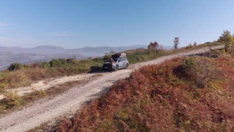 macho joven se apoya en coche todoterreno 4x4