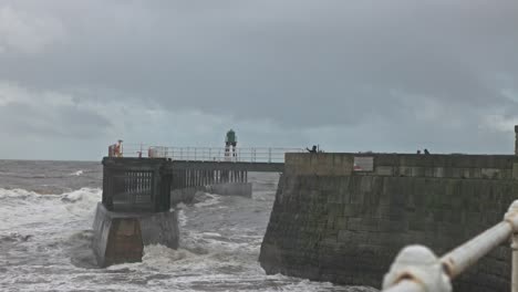 Static shot of storm waves crashing against the Whitby Harbour walls