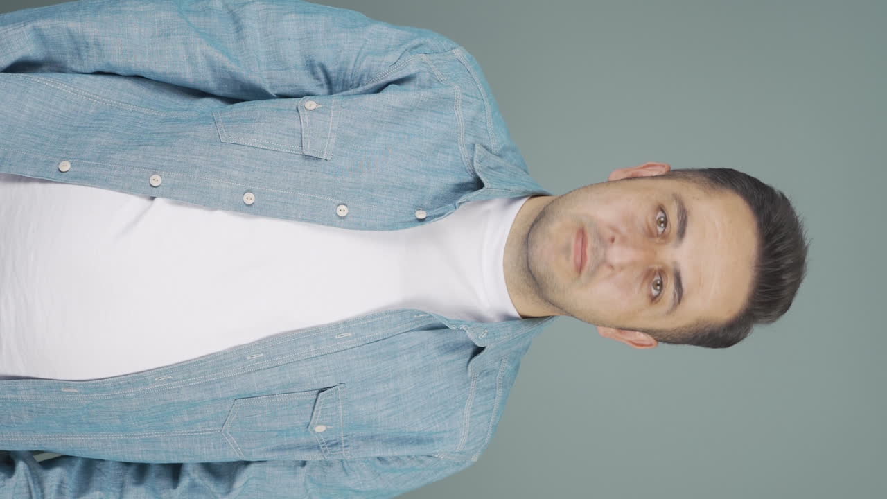 카메라를 위해 정지 표지판을 만드는 남자의 수직 비디오.