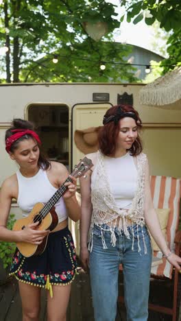 two friends playing ukulele outdoors