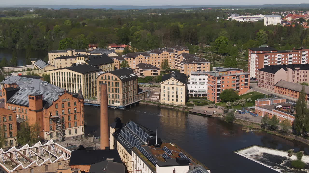 gran chimenea de mampostería de ladrillo junto a una vista aérea de la ciudad industrial, norrköping