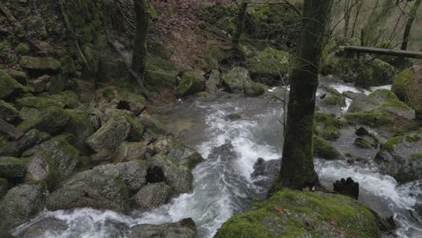 rushing river over mossy rocks in barrias, felgueiras portugal - aerial