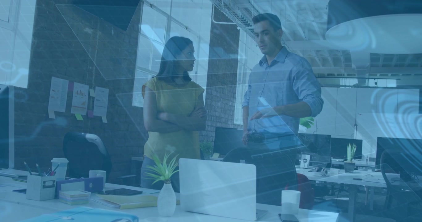 Man leaning and pointing at laptop initiating animated business charts guiding colleague to action