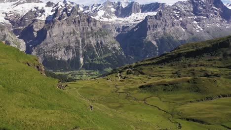 dramatic aerial view of snow-capped swiss alp mountains schreckhorn and finsteraarhorn and green meadows of grindelwald-first, bernese alps, switzerland, europe