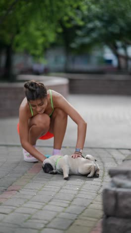 woman playing with her pug in a park