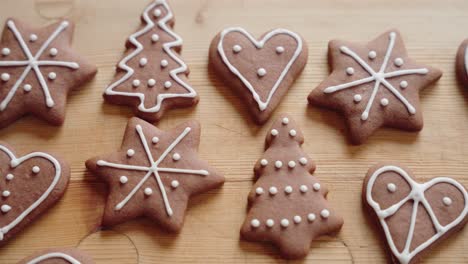 decorating gingerbread cookies for christmas, closeup macro shot making handmade festive new year sweets and cookies with white glaze icing