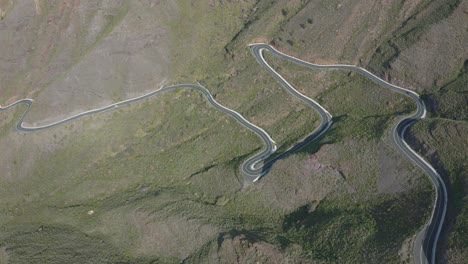 Drone-shot-of-a-curved-road-with-cars-in-the-mountain