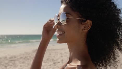 woman in sunglasses standing on the beach 4k