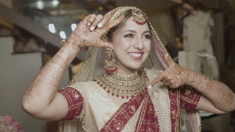 lovely indian bride with henna tattoos on her hands during wedding day