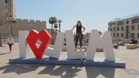 happy woman posing for camera at i love jerusalem sign, israel