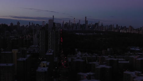 Stationary-drone-shot-of-the-New-York-City-Skyline-from-Harlem-looking-down-through-Central-Park-at-daybreak-dawn-sunrise-blue-hour