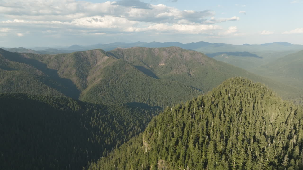 Peaks and deep, glacier carved valleys in Gifford Pinchot National Forest, aerial establishing view.